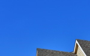 Light yellow community clubhouse and cloudless blue sky at Summit Pointe in Oklahoma City, OK